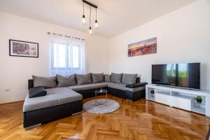 un soggiorno con divano e TV a schermo piatto di Apartment Mari a Novigrad (Cittanova)
