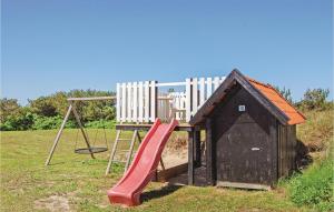 a playground with a slide and a chair at Holiday Home Astavej Løkken in Løkken
