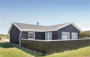 a black house with a fence in front of it at Holiday Home Astavej Løkken in Løkken +22 photos