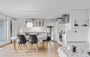 a white kitchen with a dining table and chairs at 3 Bedroom Lovely Home In Bjert in Binderup Strand