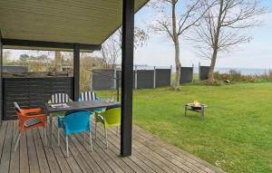 a patio with a table and chairs and a grill at 3 Bedroom Lovely Home In Bjert in Binderup Strand