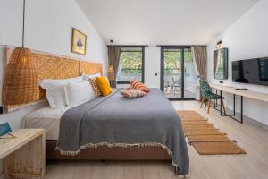 a bedroom with a bed and a desk with a television at Ölüdeniz Blu Luxury Unique Hotel - Adults-Only in Oludeniz