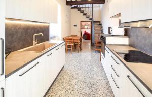 eine Küche mit weißen Schränken und ein Esszimmer in der Unterkunft 4 Bedroom Amazing Home In Cortona in Cortona