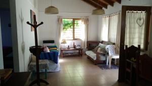 a living room with a couch and chairs and a cross at Cabaña Acacia Mansa in Villa Giardino