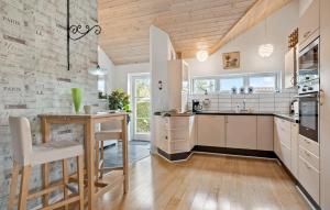 FrørupNice Home In Frørup With Wifi的厨房配有白色橱柜和木质天花板