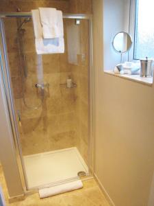 een badkamer met een douche en een glazen deur bij Oak Tree Lodge & Holiday Parking in Burstow