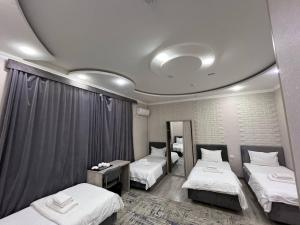 a hotel room with two beds and a mirror at Hotel Shosh Boutique in Tashkent