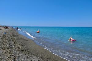 a group of people in the water at the beach at ISA-Holiday Homes in Marina di Bibbona from 400 to 900 m from the beach, apartments 6 beds with private outdoor area in Marina di Bibbona