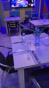 a table with a bottle of water sitting on top of it at Hôtel Ami Bamba in Mbour