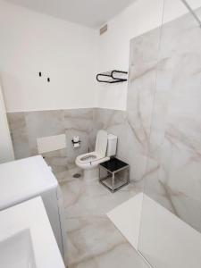 Un baño blanco con inodoro y lavabo. en Rocas del Mar 138, en Costa del Silencio