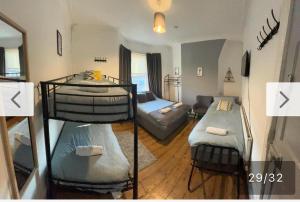 a room with three bunk beds and a living room at Rooms Anfield- 5 mins from LFC in Liverpool