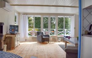 a living room with windows and a couch and a tv at Two-Bedroom Holiday Home In Dronningmolle in Dronningmølle