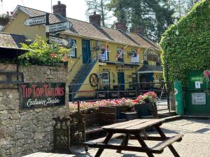 a wooden picnic table in front of a yellow building at Basil Sheils B&B Accommodation Armagh in Armagh +25 photos