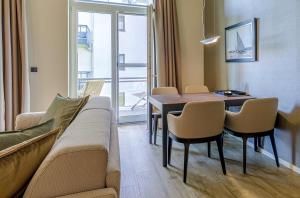 un soggiorno con un divano, un tavolo e delle sedie di Modernes Ferienapartment Ostseemöwe mit Westbalkon a Wustrow
