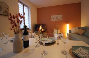 un soggiorno con tavolo, bicchieri da vino e camino di Le Shilichic - Gare a Schiltigheim