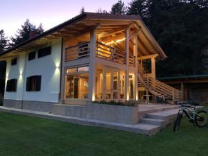 a large wooden house with a large deck at LorichiAmo B&b in Lorica