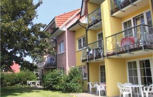 a yellow and pink building with white tables and chairs at Fewo Neuschönberg 2 Og in Neu Schönberg +14 photos