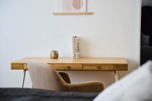 a wooden table in a room with a chair at Ajko Homes - Riverside Apartment I ruhige Lage I Balkon nähe Heidelberg in Edingen-Neckarhausen +16 photos