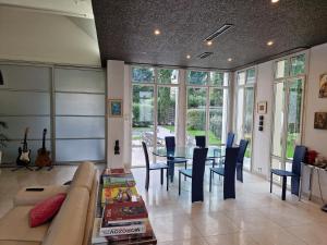 a living room with a couch and a table with chairs at Villa Castoria in Saint-Germain-en-Laye