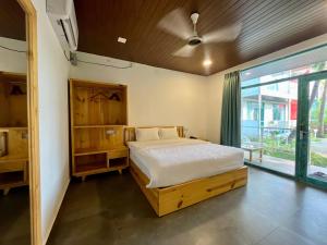 a bedroom with a bed and a large window at Magic Sand Beach Resort in Arambol
