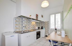 una cucina con elettrodomestici bianchi e un tavolo di 1 Bedroom Stunning Home In Perpignan a Perpignano