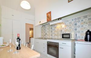 una cucina con armadi bianchi e un tavolo con bottiglie di vino di 1 Bedroom Stunning Home In Perpignan a Perpignano