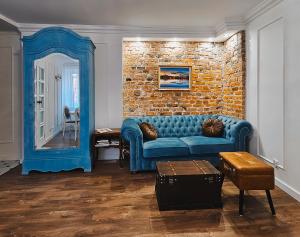 a living room with a blue couch and a brick wall at Podniebny Apartament Toruń in Toruń