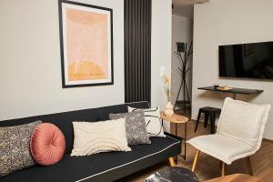 a living room with a black couch and chairs at Dream Luxury Apartment in the City Center by BiNoBi! in Thessaloniki