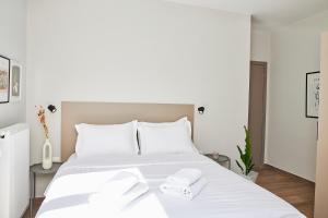 a bedroom with a white bed with towels on it at Dream Luxury Apartment in the City Center by BiNoBi! in Thessaloniki