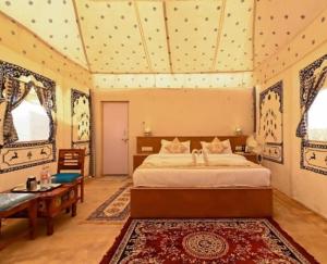 山姆Desert island Camp & Resort Jaisalmer的卧室配有床、桌子和窗户。 更多37张照片