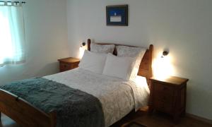 1 dormitorio con 1 cama grande y 2 mesitas de noche en Typical small house near Lisbon, en Oeiras