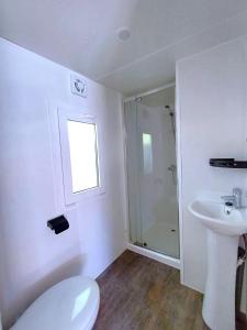 a white bathroom with a toilet and a sink at Camping Tucan - Mobile Homes by Lifestyle Holidays in Lloret de Mar