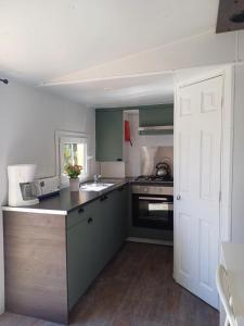 a kitchen with green cabinets and a white door at Camping Tucan - Mobile Homes by Lifestyle Holidays in Lloret de Mar