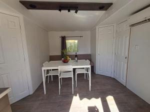 a dining room with a white table and chairs at Camping Tucan - Mobile Homes by Lifestyle Holidays in Lloret de Mar