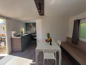 a kitchen and living room with a white table and chairs at Camping Tucan - Mobile Homes by Lifestyle Holidays in Lloret de Mar