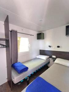a small room with two beds and a window at Camping Tucan - Mobile Homes by Lifestyle Holidays in Lloret de Mar