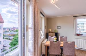 ヴァーレンにあるModernes Apartment "Stadtblick"- Aussicht auf Altstadt und Müritzのテーブルと椅子と大きな窓のあるダイニングルーム +13枚の写真