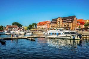 a boat is docked at a marina in a city at Ferienwohnung Seeblick - Ferienwohnung mit Ausblick auf den Yachthafen in Waren