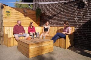a group of people sitting on a wooden bench at Ferienwohnung Hof Scholl in Rees