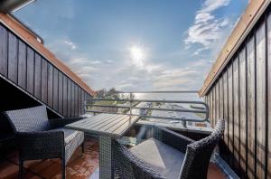 a balcony with a table and chairs and the ocean at Ferienwohnung Kietzspeicher - Maisonettewohnung im Herzen der Stadt in Waren
