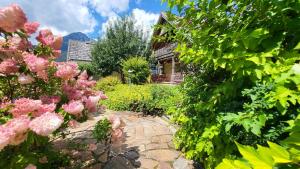 a garden with pink flowers in front of a house at Stodertraum 4 "Margerite" by Alpenidyll Apartments in Weyern