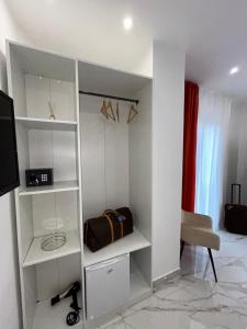 Habitación con estanterías blancas, mesa y silla en Savior Deluxe Rooms, en Nápoles