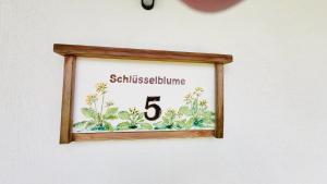 a picture of a frame on a wall with a clock at Stodertraum 5 "Schlüsselblume" by Alpenidyll Apartments in Weyern