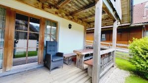 a porch with a wooden table and a chair at Stodertraum 5 "Schlüsselblume" by Alpenidyll Apartments in Weyern