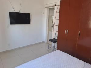 a bedroom with a bed and a flat screen tv at Apartamento no melhor bairro de Belém Cop 30 in Belém