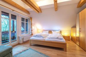 una camera da letto con un letto con lenzuola bianche e due finestre di Havelquelle mit Sauna und Garten a Kratzeburg