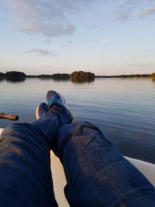 a man laying on the front of a boat on a lake at Blueberry Hill in Skånes Fagerhult +25 photos