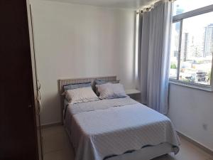 a bedroom with a bed with a white bedspread and a window at Apartamento no melhor bairro de Belém Cop 30 in Belém