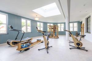 a gym with three exercise bikes in a room at 5 Sterne Apartment Boddenoase mit Ostseeblick in Wustrow