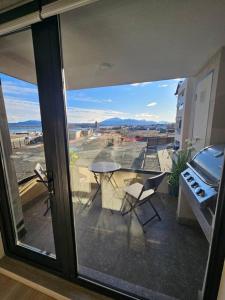 Una vista de un balcón con una mesa y sillas. en Depto Mirador del Fiordo, en Puerto Natales